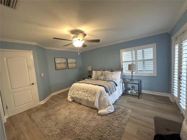 bedroom featuring light hardwood / wood-style floors, ceiling fan, and ornamental molding