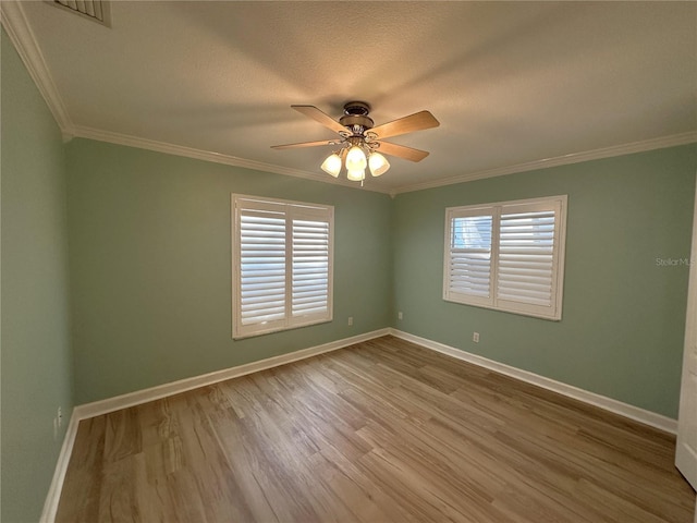 empty room featuring crown molding, ceiling fan, and hardwood / wood-style flooring