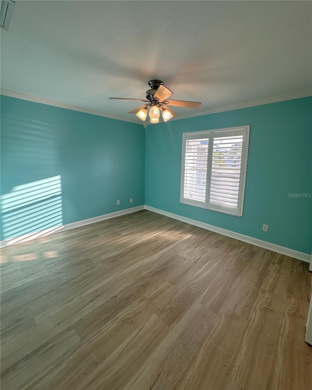 spare room with light hardwood / wood-style flooring, ceiling fan, and crown molding