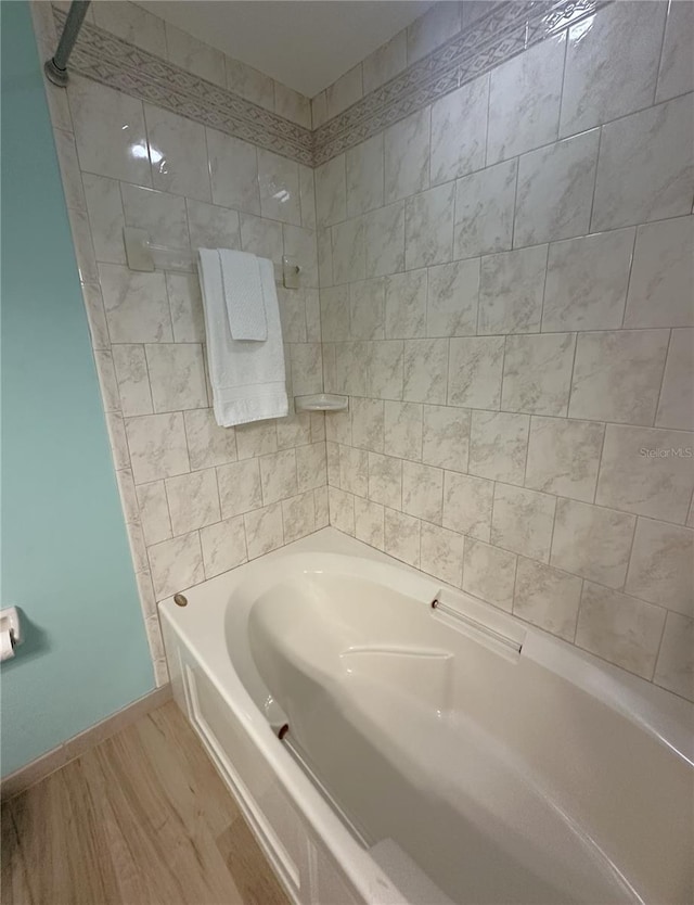 bathroom featuring hardwood / wood-style flooring and tiled shower / bath