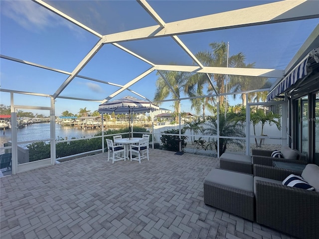 view of patio featuring a lanai and a water view