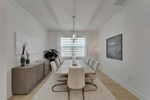 dining room with crown molding and light hardwood / wood-style floors