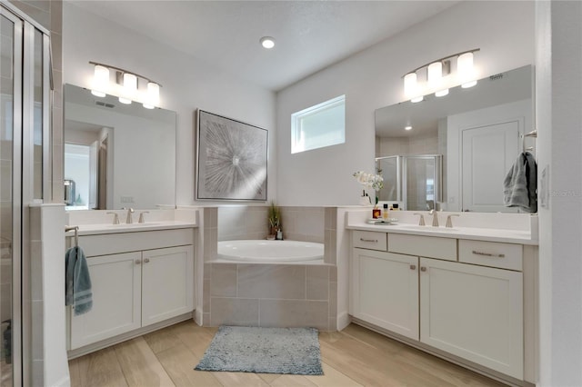 bathroom featuring hardwood / wood-style floors, vanity, and shower with separate bathtub