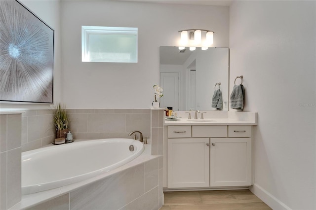 bathroom featuring vanity and tiled tub