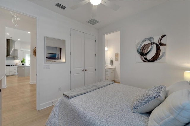 bedroom with ceiling fan, light hardwood / wood-style flooring, connected bathroom, and a closet