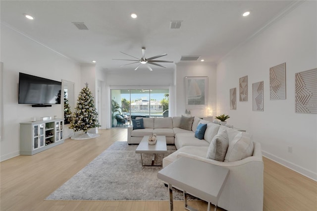 living room featuring light hardwood / wood-style floors, ceiling fan, and ornamental molding