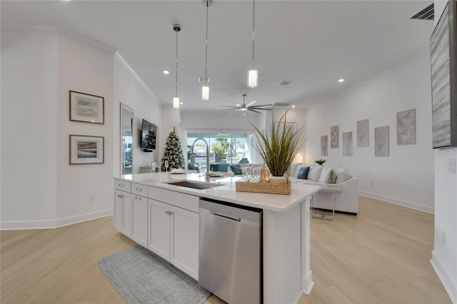 kitchen featuring sink, hanging light fixtures, stainless steel dishwasher, an island with sink, and white cabinetry