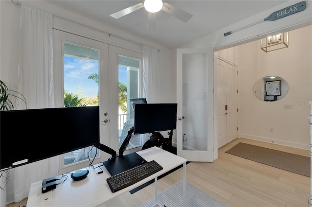 office featuring ceiling fan with notable chandelier, baseboards, wood finished floors, and french doors