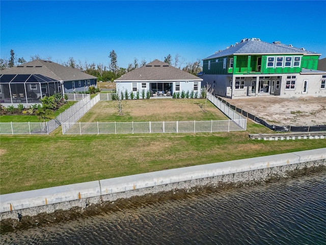 back of property with a fenced backyard, a lanai, a water view, a yard, and a patio area