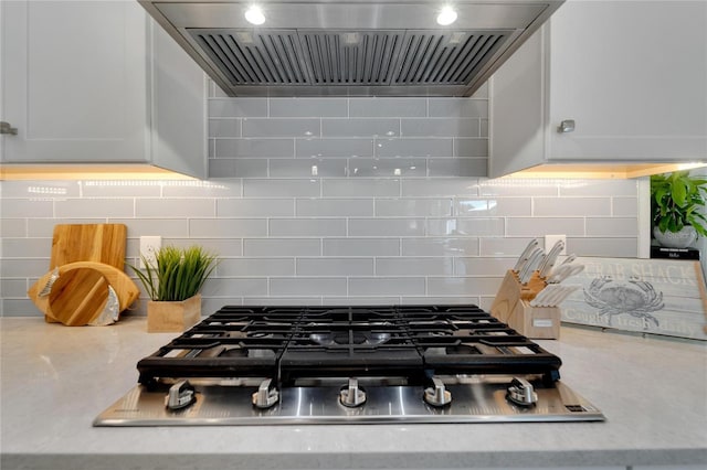 room details featuring custom exhaust hood, stainless steel gas stovetop, and backsplash
