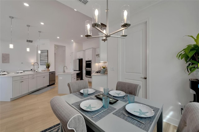 dining room featuring light wood-type flooring, a chandelier, ornamental molding, and recessed lighting