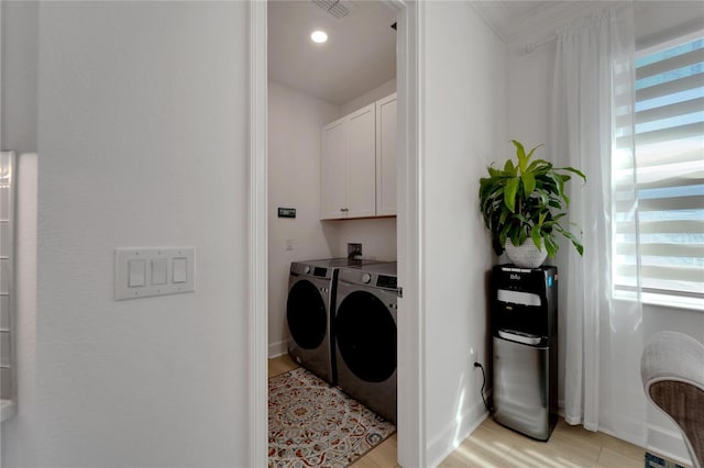 clothes washing area featuring cabinet space, washer and dryer, light wood-type flooring, and baseboards