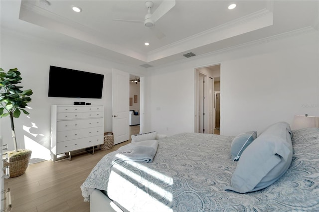 bedroom with a raised ceiling, light wood-style floors, recessed lighting, crown molding, and ceiling fan