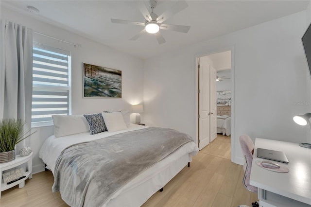 bedroom with light wood finished floors, baseboards, and ceiling fan