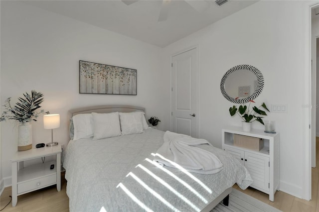 bedroom with baseboards, light wood-type flooring, and ceiling fan