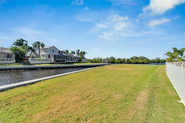 view of yard with a water view and fence