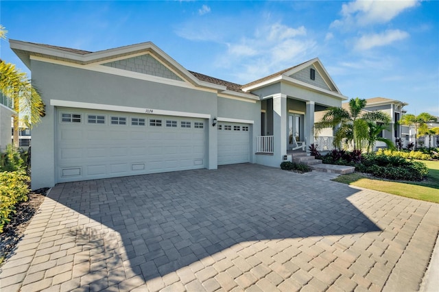 ranch-style house with decorative driveway, stucco siding, a garage, and covered porch