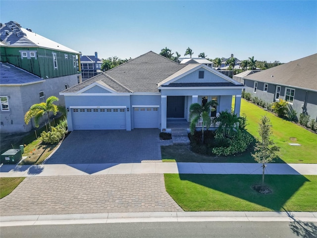 view of front of home with asphalt driveway, a garage, a porch, and a front lawn