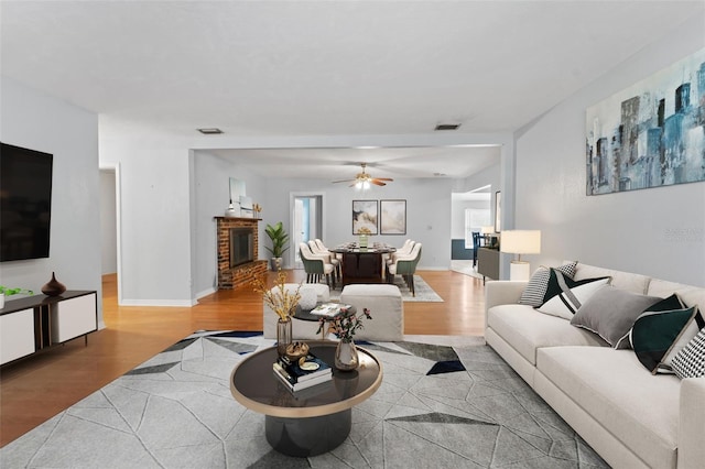 living room featuring ceiling fan and light hardwood / wood-style flooring