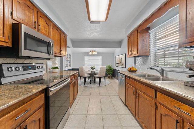 kitchen featuring light tile patterned floors, appliances with stainless steel finishes, sink, and a healthy amount of sunlight