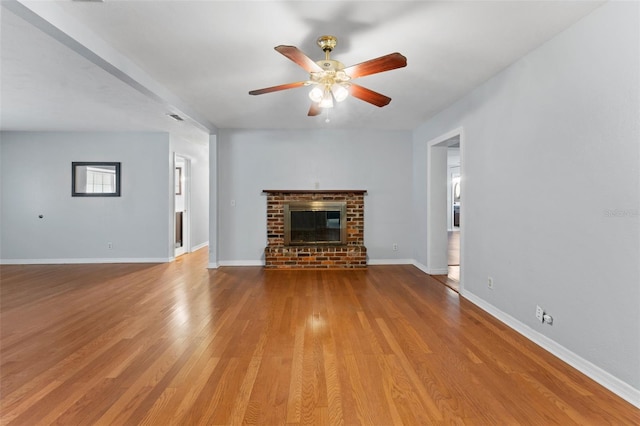 unfurnished living room with a brick fireplace, light hardwood / wood-style floors, and ceiling fan