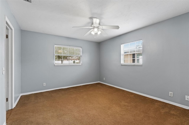 carpeted spare room with ceiling fan and a healthy amount of sunlight