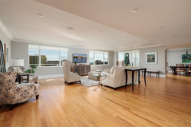 living room featuring a healthy amount of sunlight, ornamental molding, and light hardwood / wood-style flooring