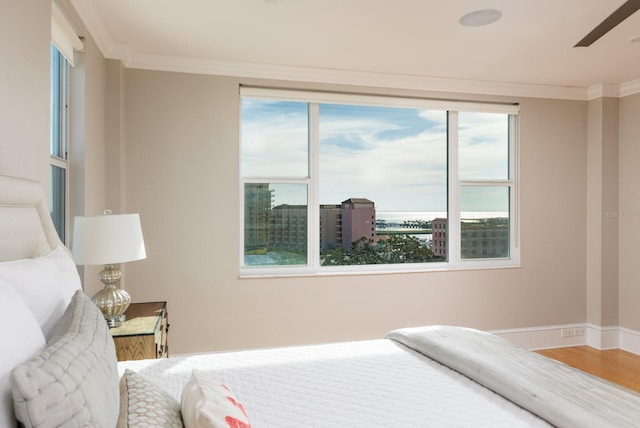 bedroom featuring ceiling fan, crown molding, and multiple windows