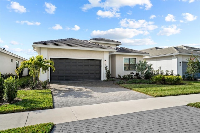 17702 Cresswind Ter, Bradenton, FL 34211 - prairie-style house featuring a garage, decorative driveway, a front lawn, and stucco siding