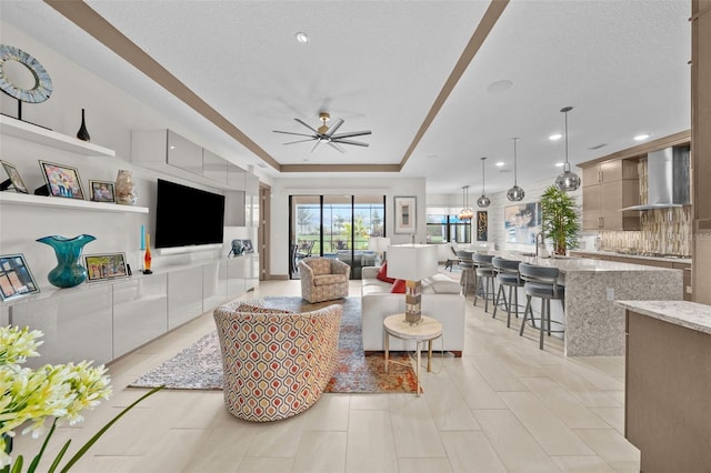 17702 Cresswind Ter, Bradenton, FL 34211 - living area with a tray ceiling, ceiling fan, and recessed lighting