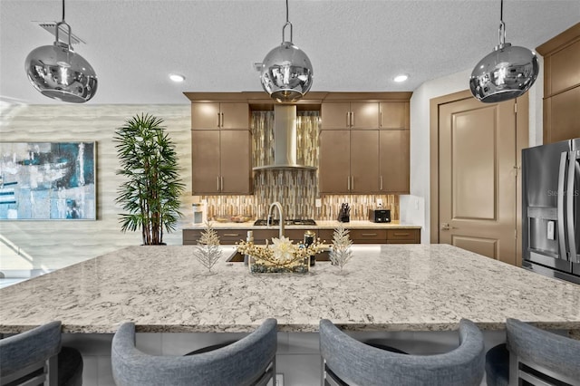 17702 Cresswind Ter, Bradenton, FL 34211 - kitchen featuring wall chimney exhaust hood, stainless steel appliances, recessed lighting, light stone counters, and a textured ceiling