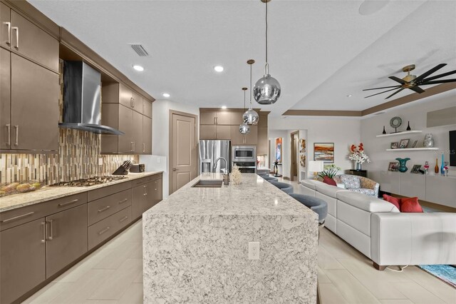 17702 Cresswind Ter, Bradenton, FL 34211 - kitchen with a sink, wall chimney range hood, stainless steel appliances, open floor plan, and tasteful backsplash