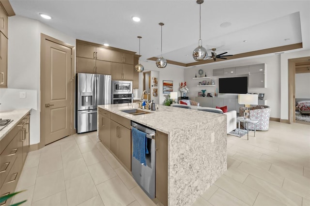 17702 Cresswind Ter, Bradenton, FL 34211 - kitchen with stainless steel appliances, a sink, ceiling fan, hanging light fixtures, and a center island with sink