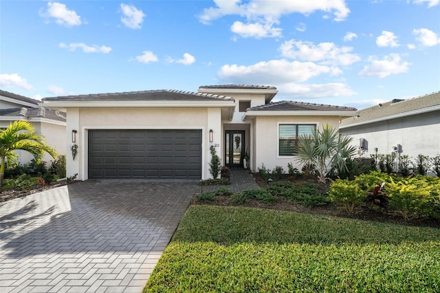 17702 Cresswind Ter, Bradenton, FL 34211 - prairie-style house featuring an attached garage, decorative driveway, stucco siding, and a front lawn