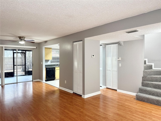 unfurnished living room with ceiling fan, a textured ceiling, and light wood-type flooring