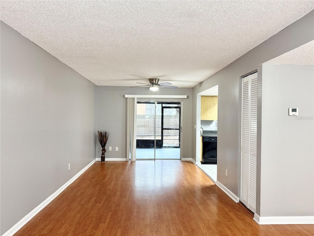 unfurnished room featuring ceiling fan, light hardwood / wood-style flooring, and a textured ceiling