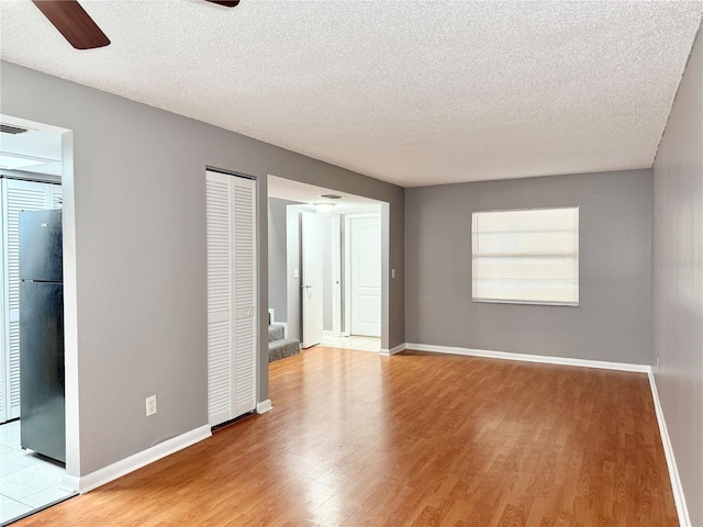 unfurnished room featuring hardwood / wood-style floors, ceiling fan, and a textured ceiling