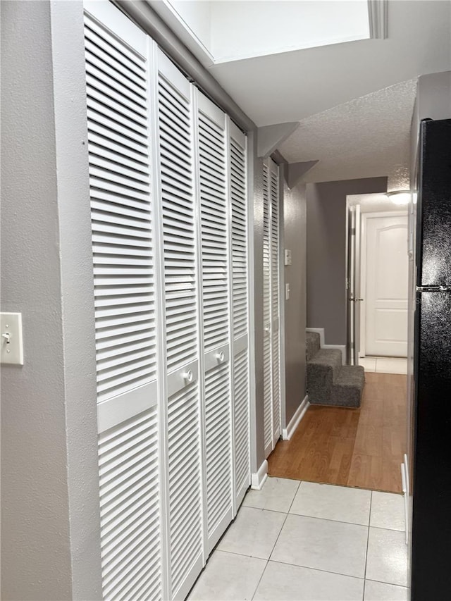 hall featuring light tile patterned floors