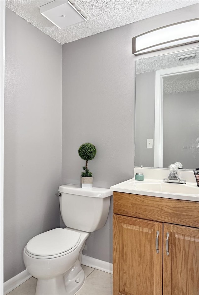 bathroom featuring vanity, a textured ceiling, tile patterned floors, and toilet