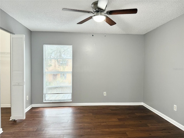 unfurnished room with a textured ceiling, ceiling fan, and dark wood-type flooring