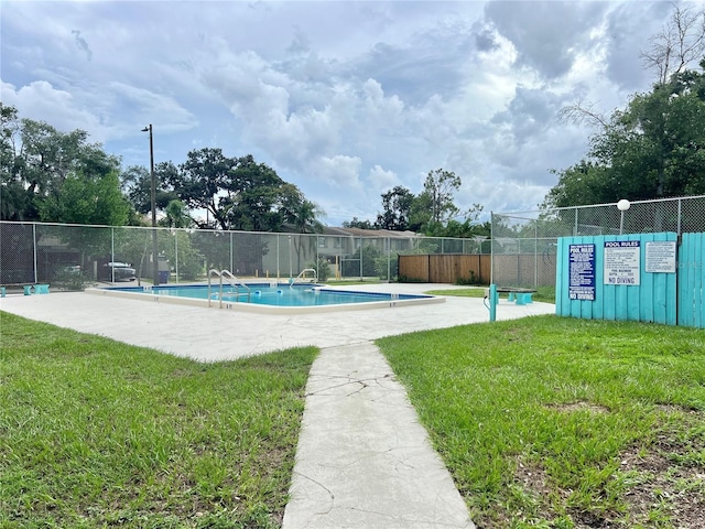 view of swimming pool with a lawn