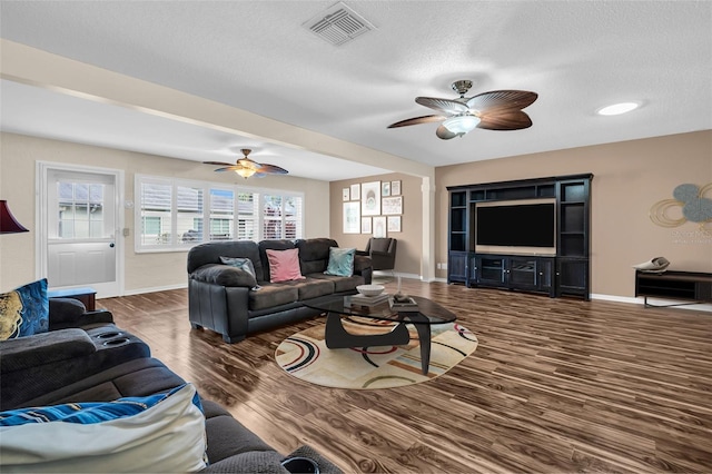 living room featuring a textured ceiling and dark wood-type flooring