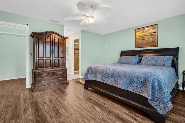 bedroom with dark wood-type flooring, ceiling fan, and a closet