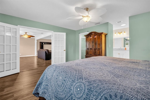 bedroom with ceiling fan, dark hardwood / wood-style flooring, connected bathroom, and sink