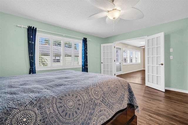 bedroom featuring ceiling fan, french doors, dark wood-type flooring, and a textured ceiling