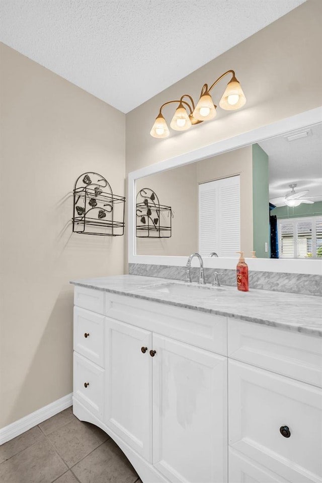 bathroom with ceiling fan, a textured ceiling, vanity, and tile patterned flooring