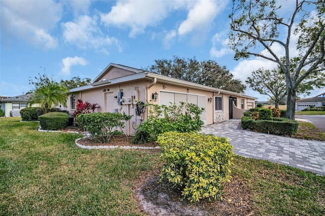 ranch-style home featuring a garage and a front lawn