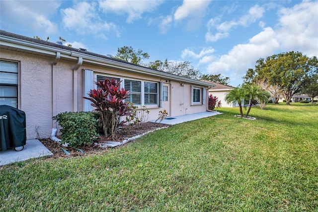 rear view of property with a yard and a patio