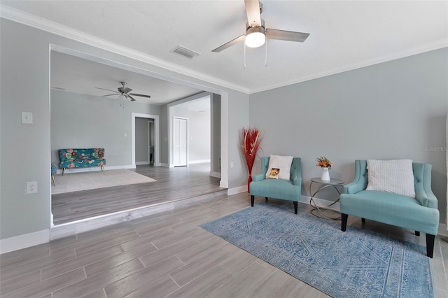 sitting room with ceiling fan, wood-type flooring, and crown molding