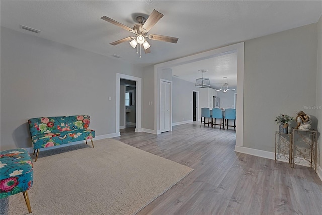 living area featuring ceiling fan and light hardwood / wood-style flooring